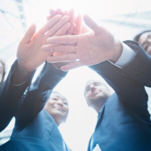 複数人が手を重ねている（画像はイメージです）