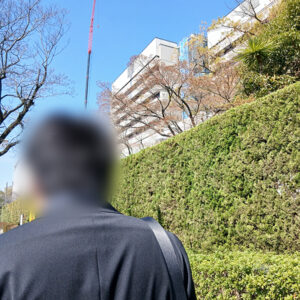 名古屋市内の大学での実習面談会へ向かう訓練生。背景にそびえるビル群を背に、求人票だけでは分からない『職場の空気感』を肌で感じるための大切な一歩