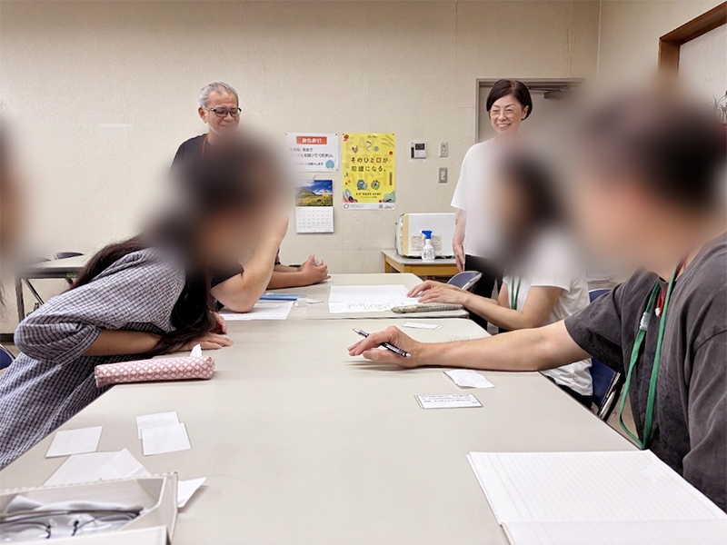 自分のカードに書かれた情報を仲間に分かりやすく口頭で伝えるトレーニング。自分だけの情報に囚われず、全員の意見を統合して「宝物の場所」を導き出そうと、活発に意見を出し合い視野を広げている場面。