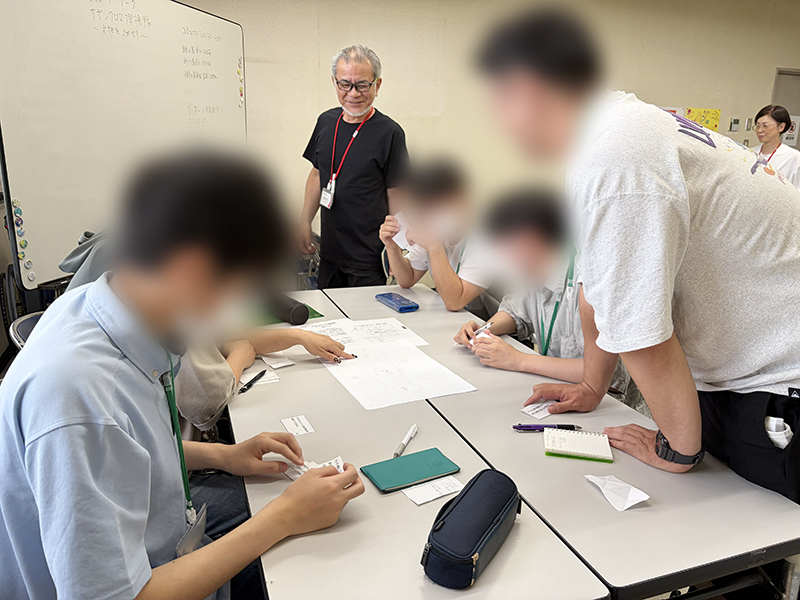 障碍者ITカレッジ愛西にて、グループワーク「サザンクロス探検隊」に取り組む訓練生たち。ワーク開始前に確認した「相手の言葉を最後まで聴く」「役割分担をする」といった4つの約束を意識しながら、チーム一丸となって課題に挑む様子。
