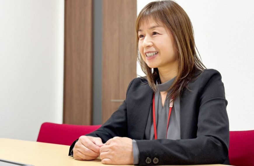 障碍者ITカレッジ愛西の就労支援員、安井よしえ。利用者のKさんが「おとなしく静かな印象」から、自分に合った職場を見つけ、自信に満ちた表情へと変化していった軌跡を温かな笑顔で振り返るインタビューシーン。